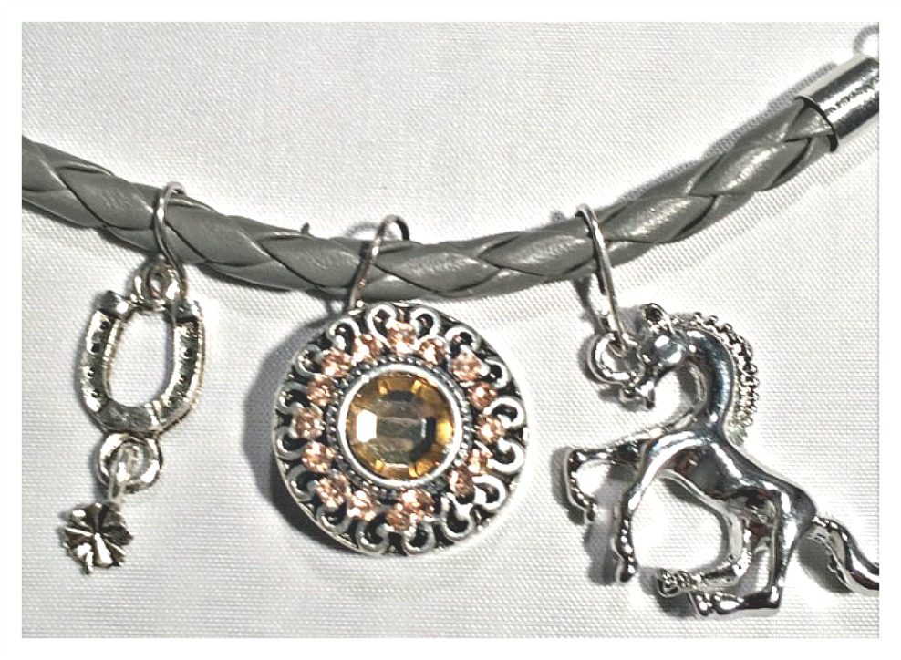 silver-horse-yellow-crystal-snap-horseshoe-charms-on-grey-braided